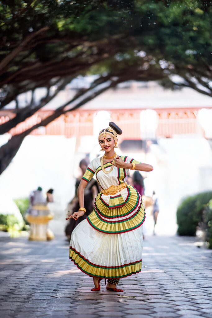 A skilled Bharatanatyam dancer performs in traditional attire in a serene Kerala garden setting.