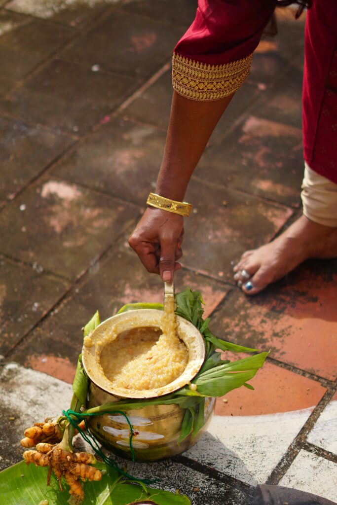 A close-up of a Pongal ritual with a pot of sweet dish being prepared, symbolic in South India.